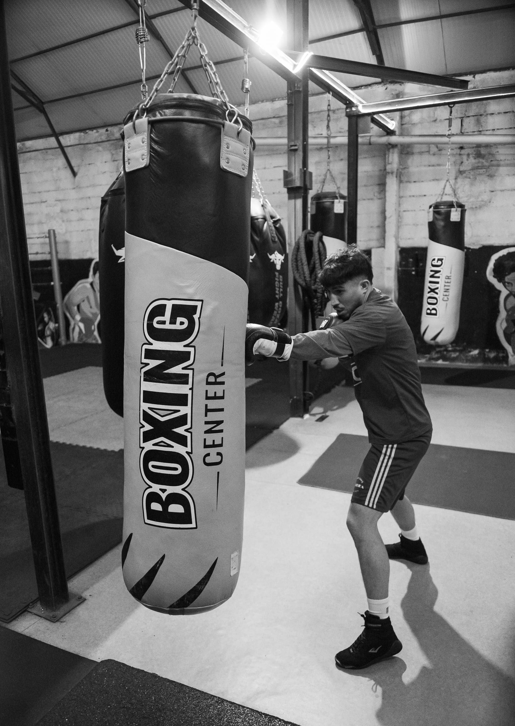 Un boxeur travaille sur un sac Boxing Center dans la salle d'entraînement.