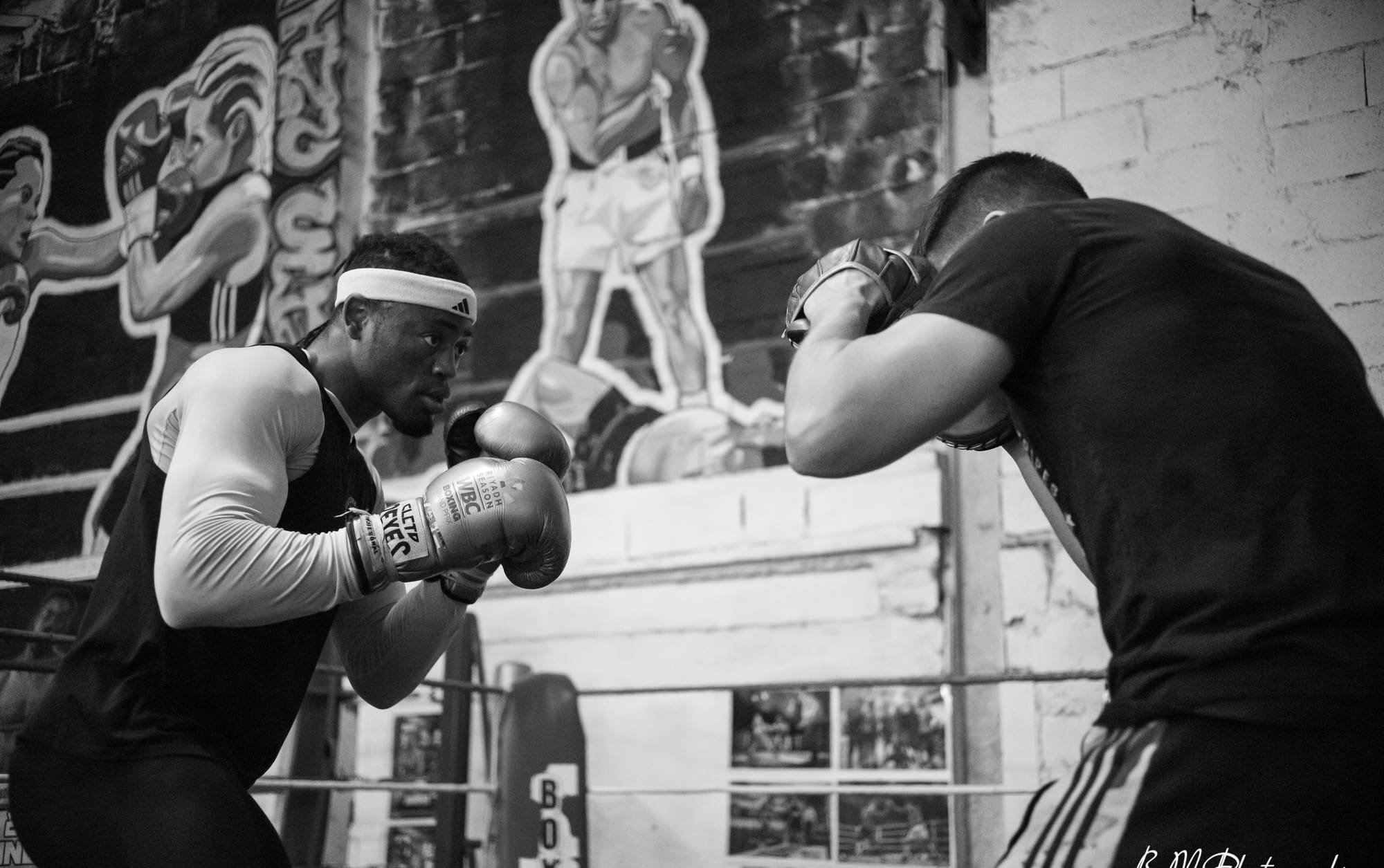 Deux pratiquants au corps à corps pendant un exercice, en noir et blanc.